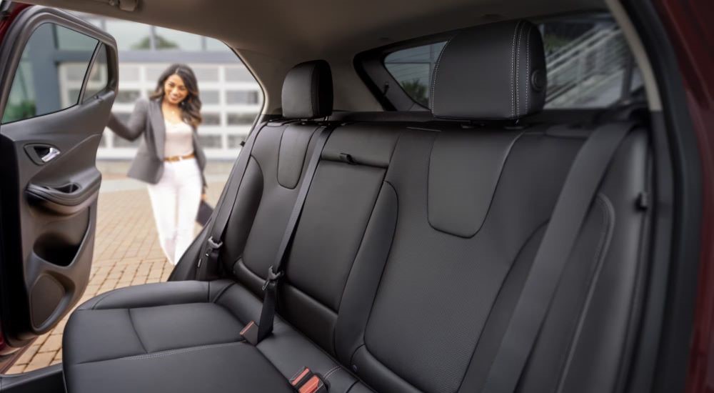 A person is shown opening the door of a 2024 Buick Encore GX  Avenir.