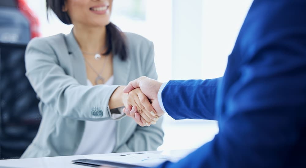 Two people shaking hands while i sell my car.