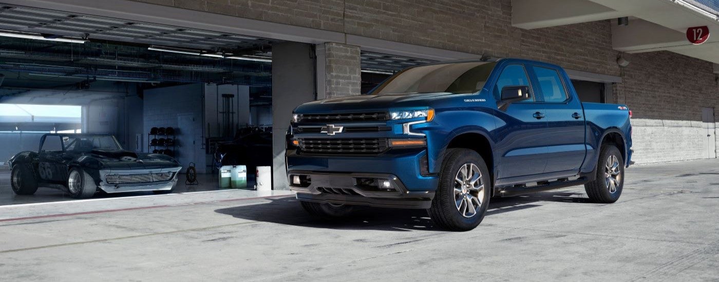 Blue 2019 Chevy Silverado 1500 parked near a garage.