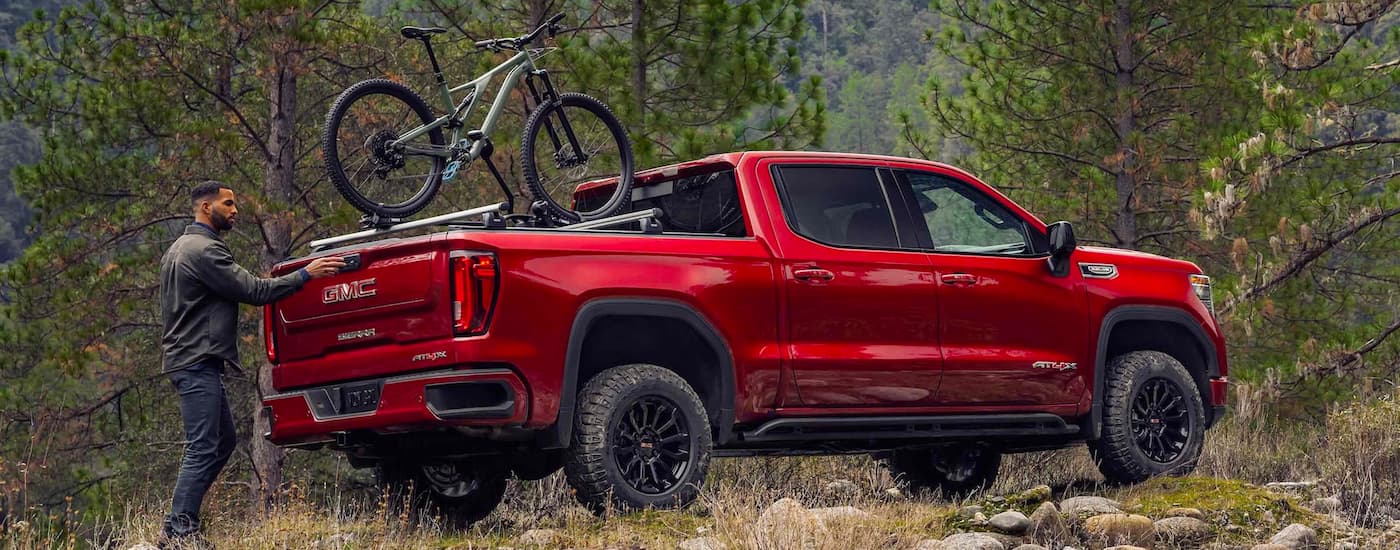 Red 2023 GMC Sierra 1500 AT4X with a bike in the bed