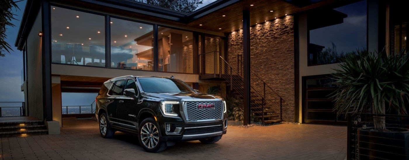 Black 2023 GMC Yukon Denali parkd on a driveway.