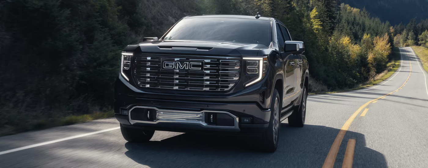 Black 2026 GMC Sierra 1500 Denali driving on an open road