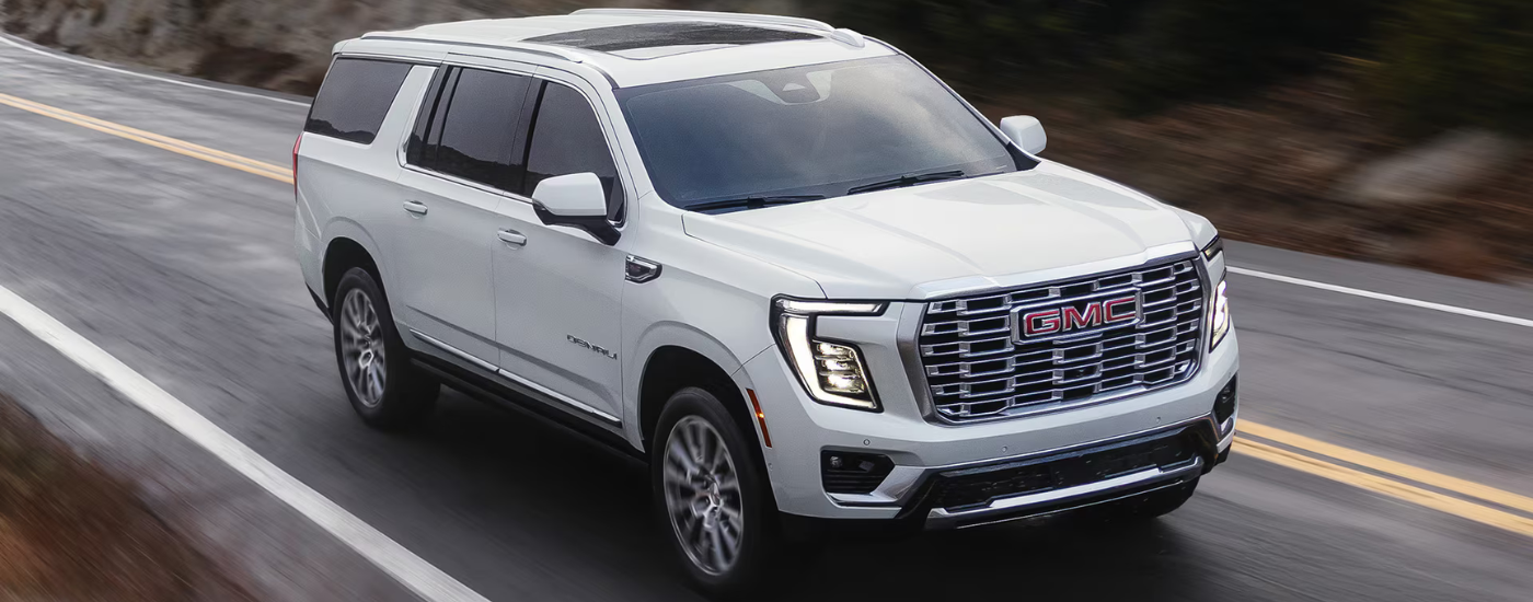 White 2026 GMC Yukon driving along an open road
