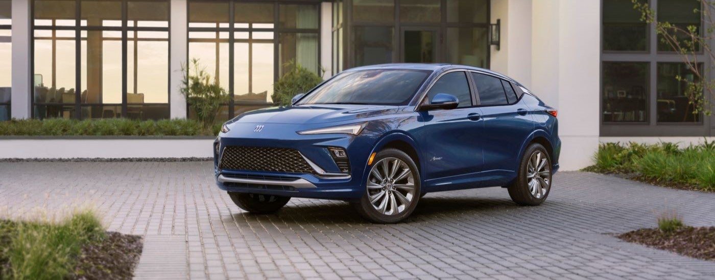 A blue 2024 Buick Envista is shown parked outside a building near a Buick dealer.