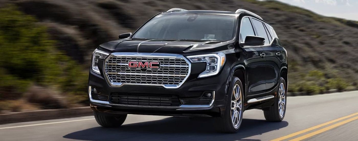 A black 2023 GMC Terrain Denali is shown driving.