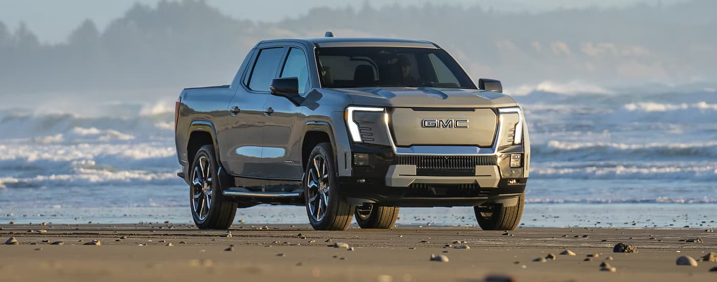 Tan 2025 GMC Sierra EV parked on a beach.