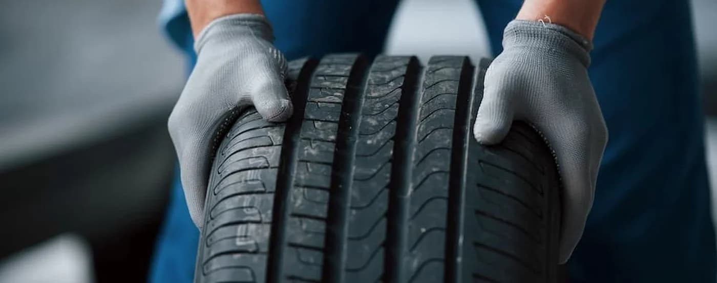 Close-up on a mechanic rolling a tire.